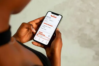 Person holding a smartphone displaying a job application interface