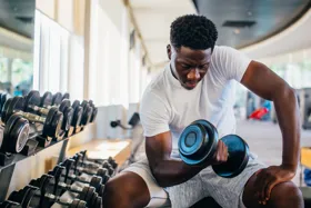 Man lifting a dumbbell in a gym